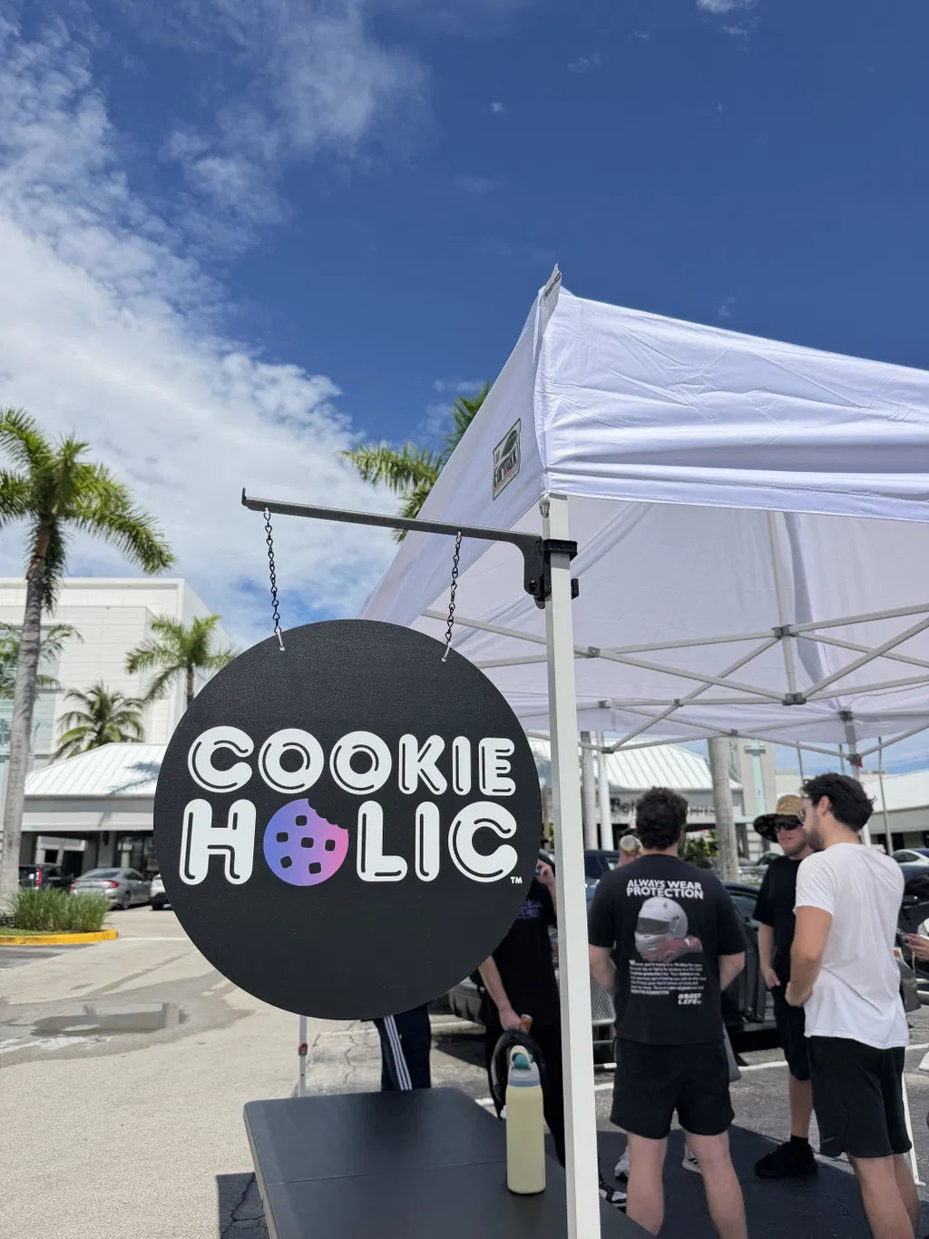 Vendor sign hanging from a MomentLock mount on a canopy leg